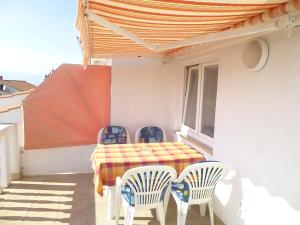 un tavolo e sedie sul balcone di una casa di Apartments Vila Lavanda a Omišalj (Castelmuschio)