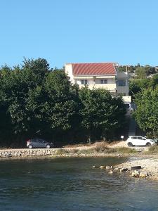 two cars parked on the side of a river at Apartments Nikola Caska in Novalja