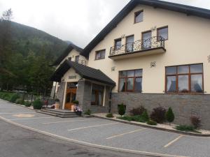 un bâtiment situé sur le côté d'une route dans l'établissement Penzión Hučava, à Vysoké Tatry