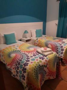 ヴィラ・ノヴァ・デ・ミルフォンテスにあるApartamento Alagoinhaのベッドルーム1室(カラフルな掛け布団付きのベッド2台付)