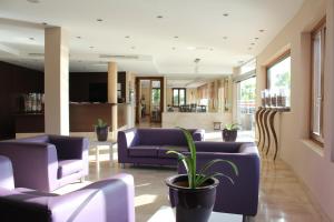 una hall con divani viola e una pianta in vaso di Aparthotel Puerto Mar a Peñíscola