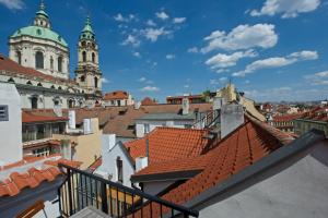 a view of roofs of a city with two towers at Residence U Mecenáše in Prague