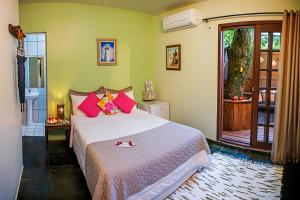 een slaapkamer met een groot bed met roze kussens bij Pousada e Restaurante Fim da Trilha in Ilha do Mel