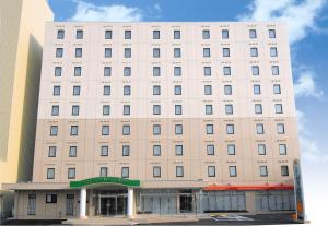 a white building with a store in front of it at Hotel Unisite Mutsu in Mutsu