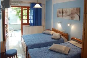 2 camas en un dormitorio con paredes azules en Anais Studios, en Patitiri