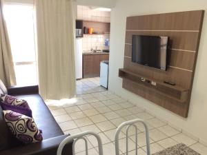 a living room with a couch and a flat screen tv at Apartamento Ecologic Park Caldas Novas in Caldas Novas