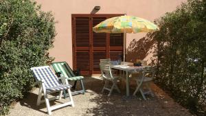 フルナリにあるCasa vacanze Portorosaのテーブル(椅子2脚、傘付)