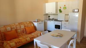 フルナリにあるCasa vacanze Portorosaのリビングルーム(ソファ、テーブル付)、キッチンが備わります。