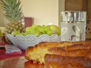 a glass of water and a plate of bread and a bowl of fruit at Gelsomino B&B in Ispica