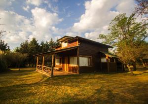 a small house sitting in a field of grass at Cabañas Cuatro Horizontes in Villa General Belgrano