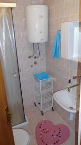 uma casa de banho com um chuveiro, um WC e um lavatório. em Apartments Marija & Ivana, Malinska em Malinska