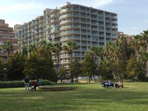 オロペサ・デル・マールにあるApartamento Marina D'Or 1ª linea de playaの大きな建物前の公園に座る人々