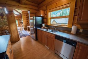 a kitchen with a refrigerator and a sink in a cabin at Alpine Meadows Resort in Clearwater