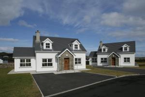 a large white house with a black roof at Downings Coastguard Cottages - Type B-E in Downings