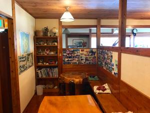 a room with a table and a book shelf at Minshuku Yakushima in Yakushima