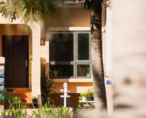 une maison avec une porte noire et un arbre dans l'établissement Zeroplus旅宿 渡假包棟villa, à Hengchun Old Town