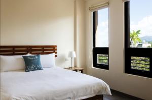 une chambre avec un lit et une fenêtre dans l'établissement Zeroplus旅宿 渡假包棟villa, à Hengchun Old Town