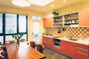 une cuisine avec des armoires orange et une table en bois dans l'établissement Zeroplus旅宿 渡假包棟villa, à Hengchun Old Town