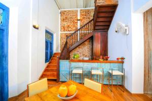 a dining room with a table and a staircase at Handun Villas in Talalla