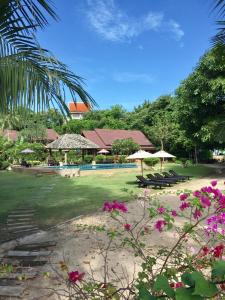 un complejo con piscina y algunas flores rosas en Baan Laem Noi Villa's en Mae Nam Beach