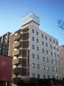苫小牧市にあるホテル苫小牧グリーンヒルズの上に看板がある白い建物