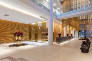 un vestíbulo con un jarrón de flores en un edificio en SKYE Hotel Suites Parramatta en Sídney