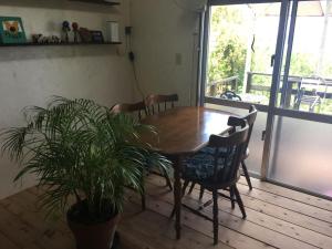 a dining room table with chairs and a potted plant at Minami Onna Tropical in Onna