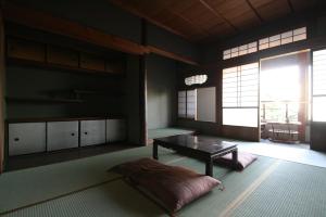 un soggiorno con un tavolo e una grande finestra di HARUYA Naramachi a Nara