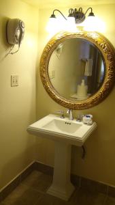 a bathroom with a white sink and a mirror at Coronado Motor Hotel in Yuma