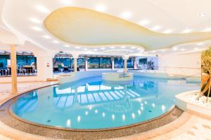 a large swimming pool in a building with a ceiling at Royal Hotel Hinterhuber in Brunico