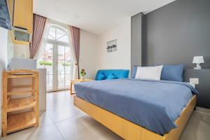 a bedroom with a blue bed and a window at Babylon D3 Serviced Apartment in Ho Chi Minh City