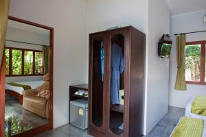 a room with a wooden cabinet and a bedroom at Ardea Resort Pool Villa in Amphawa