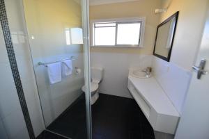 a bathroom with a shower, sink, and toilet at City Centre Apartments in Grafton