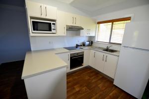 a kitchen with white cabinets and white appliances at City Centre Apartments in Grafton