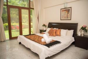 a bedroom with a large bed with pillows at Hermitage Suites Koregaon Park Garden & Terrace Room in Pune