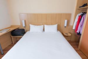 a bed with two white pillows in a bedroom at ibis Dunkerque in Dunkerque