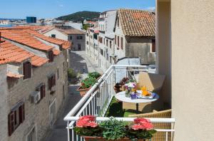 a balcony with a table and flowers on a city street at Royal Suites in Split