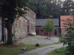 a large brick building with a tree in front of it at Lindstedter Gutsstuben in Gardelegen