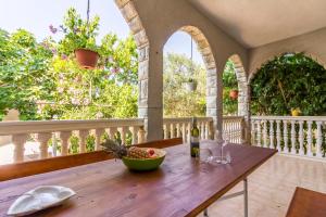 a wooden table with a bowl of fruit on a balcony at Apartments Tamara in Medulin
