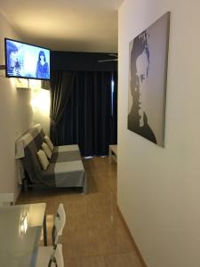 a living room with a couch and a tv on a wall at Benal Beach Apartment in Benalmádena