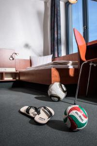 バート・ブランケンブルクにあるLandessportschule Bad Blankenburgのベッドルーム1室(サッカーボール付きのベッド1台、スリッパ付)