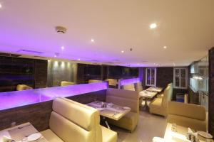 a dining room with purple lighting in a restaurant at Hotel SRR Grand in Chennai