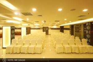 een kamer met rijen witte stoelen erin bij Hotel SRR Grand in Chennai