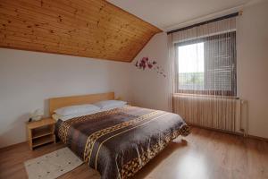 - une chambre avec un grand lit et une fenêtre dans l'établissement Apartments Božić, à Grabovac