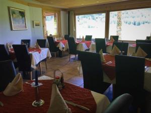 a restaurant with tables and chairs in a room at Hotel Pizzeria Selva in Zernez