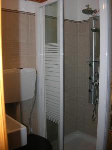 een badkamer met een douche, een toilet en een wastafel bij Apartment Next to the Sea in Poseidonia in Posidhonía