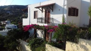 a white house with flowers on the side of it at Elina Apartments in Batsi