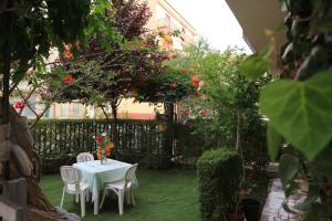 un tavolo e sedie in un giardino con fiori di B&B Macalube Aragona ad Aragona