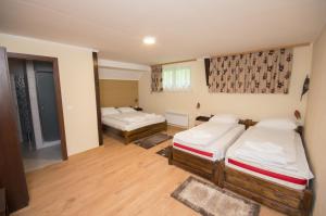 um quarto com duas camas num quarto em Sziklakert Fogadó em Sâncrai
