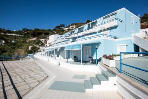 um edifício azul com escadas em frente em Magi - Appartamenti Maga Circe em Ponza